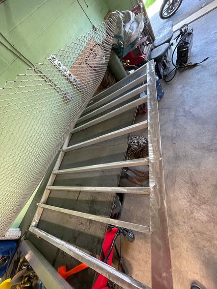 Aluminum trailer ramp frame with expanded metal being fitted in the shop