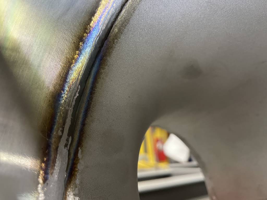 Close-up of a TIG weld bead with heat coloring on stainless